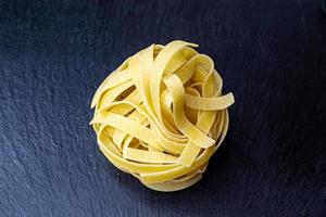 droog Italiaans tagliatelle pasta achtergrond gezond voedsel foto