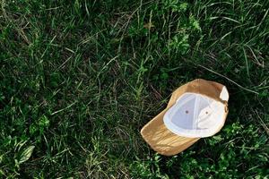 een geel sport- pet leugens ondersteboven naar beneden Aan de groen gras. voorjaar buitenshuis sport- spellen foto