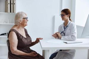 ouderen vrouw met bril communiceert met de dokter Gezondheid zorg foto