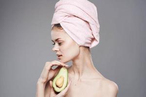 elegant vrouw Holding een roze handdoek Aan haar hoofd in haar hand- exoten fruit schoon huid schoonheidsmiddelen foto