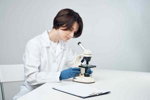 vrolijk vrouw laboratorium assistent in wit jas microscoop professioneel wetenschap experimenten foto