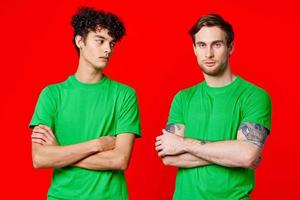 twee vrienden groen t-shirts communicatie levensstijl rood achtergrond foto