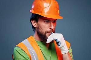 Mens in werk uniform oranje verf veiligheid werk vermoeidheid blauw achtergrond foto