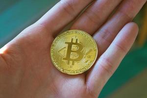 man met bitcoin in de hand foto