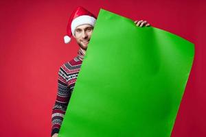 emotioneel Mens in een de kerstman hoed Holding een banier vakantie geïsoleerd achtergrond foto