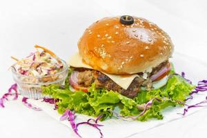 een groot grootte hamburger pasteitjes van grond rundvlees met sla blad en koolsalade salade. foto