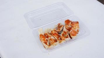 pittig dimsum in plastic doos Aan wit achtergrond, Aziatisch voedsel foto