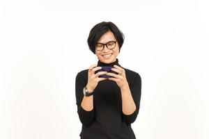 spelen mobiel spel Aan smartphone van knap Aziatisch Mens geïsoleerd Aan wit achtergrond foto