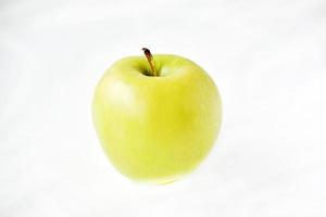 een heldergroene appel op een witte achtergrond foto