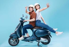 jong Aziatisch paar rijden scooter Aan achtergrond foto