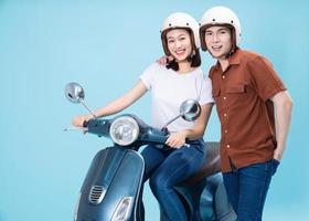 jong Aziatisch paar rijden scooter Aan achtergrond foto