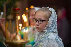 orthodox pasen.tiener meisje in een hoofddoek in een kerk. foto