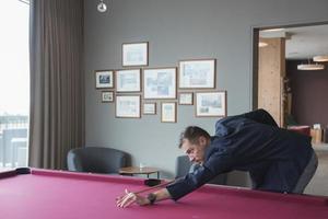 mannetje toerist nemen schot terwijl spelen snooker in luxe hotel foto