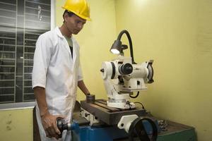 Bangladesh mei 20, 2015 een fabriek laboratorium operator gebruik makend van staal hengel kwaliteit testen machine een foto