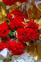kleurrijk rood en gouden bloem en verlichting bruiloft stadium decoratie. plastic kunstmatig bloem. bruiloft decoratie. foto