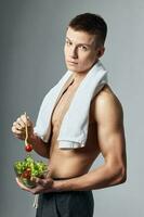schattig topless vent handdoek over- zijn schouders bord van salade foto