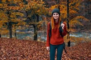 herfst park gedaald bladeren hoog bomen rivier- in de achtergrond en vrouw reizen toerisme foto