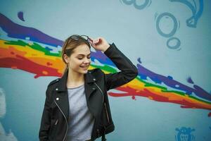 Dames in de buurt de graffiti Aan de muur in de het formulier van een regenboog foto