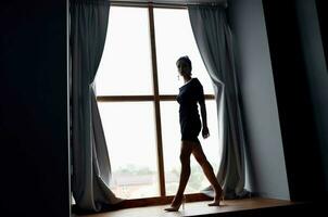 vrouw silhouet in de buurt venster interieur poseren model- foto