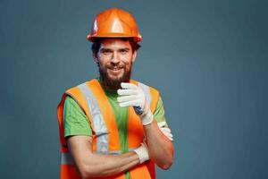 een Mens in een werk uniform is een bouw ingenieur. industrie professioneel oranje moeilijk hoed foto