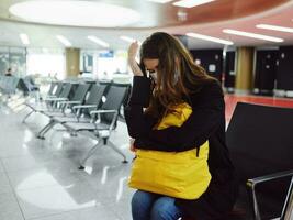 luchthaven vrouw met bagage in medisch masker vlucht vertraging foto