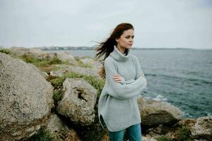 portret van een vrouw strand toerisme bewolkt weer steen kust levensstijl foto