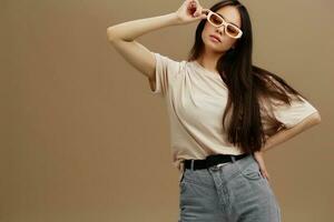 brunette in een beige t-shirt met bril poseren kleding mode studio model- foto
