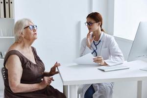 ouderen vrouw met bril examen door een dokter stethoscoop foto