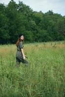 vrouw in de weide wandelen in groen jumpsuit zwart pet foto