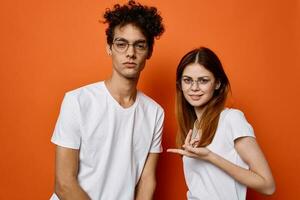 schattig mannen en Dames wit t-shirt emotie mode oranje achtergrond foto