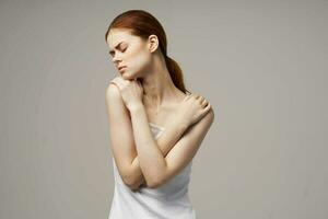 vrouw in wit t-shirt Holding Aan naar de nek Gezondheid problemen gewricht studio behandeling foto