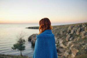 vrouw in natuur schuilplaats met een deken in de ochtend- bewondert de landschap foto