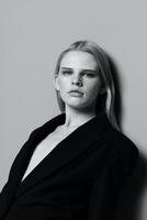 een groot portret van een elegant meisje in een modieus zwart jasje in de studio. zwart en wit stijl. concept voor kleding merken foto