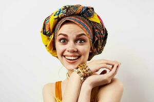 vrolijk vrouw met veelkleurig tulband Aan haar hoofd decoratie poseren foto