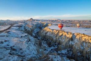 heteluchtballonnen vliegen over Cappadocië in de winter, Goreme, Turkije foto
