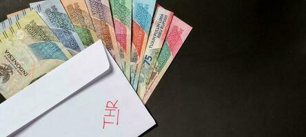 nieuw bankbiljetten uitgegeven in 2022 van rp. 1.000 naar rp. 100.000. Indonesisch roepia valuta met een wit envelop gelabeld door. tunjangan hari raya concept, negatief ruimte foto