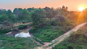 zonsondergang visie van een trein venster in landelijk Indisch dorp foto