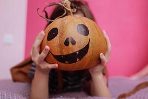 fijne Halloween. meisje met een carving pompoen. gelukkige familie halloween voorbereiden. foto