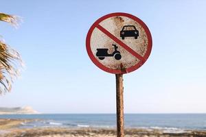 oud geen auto's, geen motorfietsen ondertekenen op het strand en de blauwe hemelachtergrond op zonnige dag. foto