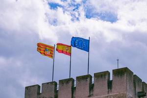 Europese unie en aragon Spanje vlaggen tegen de lucht Aan een steen historisch kasteel foto