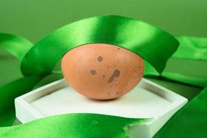 Pasen eieren Aan een wit podium met een groen lint Aan een groen achtergrond foto