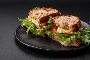 heerlijk caprese belegd broodje met gegrild geroosterd brood, Mozzarella, sla en tomaten foto