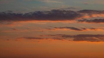 zacht diep oranje lucht, verlichte wolken Bij bloederig zonsondergang net zo een achtergrond. foto