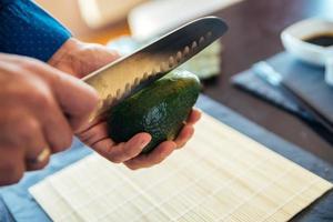 chef-kok een avocado open snijden foto