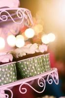 bruiloft cupcakes met kleurrijk hagelslag in groen kop met slinger lichten bokeh achtergrond foto