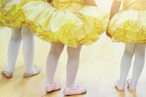 weinig meisjes in geel ballet tutu jurk en roze ballet schoenen. foto