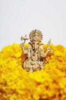 goud ganesha standbeeld god is de heer van succes god van hindoeïsme Aan goudsbloem bloemen geïsoleerd Aan wit achtergrond. foto