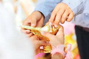 hand- hoding schelp schelp in traditie Thais bruiloft ceremonie foto