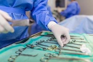 dokter en assistent verpleegster in werking voor helpen geduldig van gevaarlijk noodgeval geval .chirurgisch instrumenten Aan de steriel tafel in de noodgeval operatie kamer in de ziekenhuis.gezondheid zorg en medisch foto