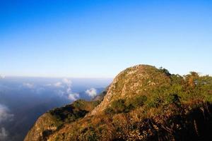 zonsopkomst in ochtend- met lucht en wolk Aan de kalksteen berg. zonnestraal met mist en de nevel Hoes de oerwoud heuvel in Thailand foto